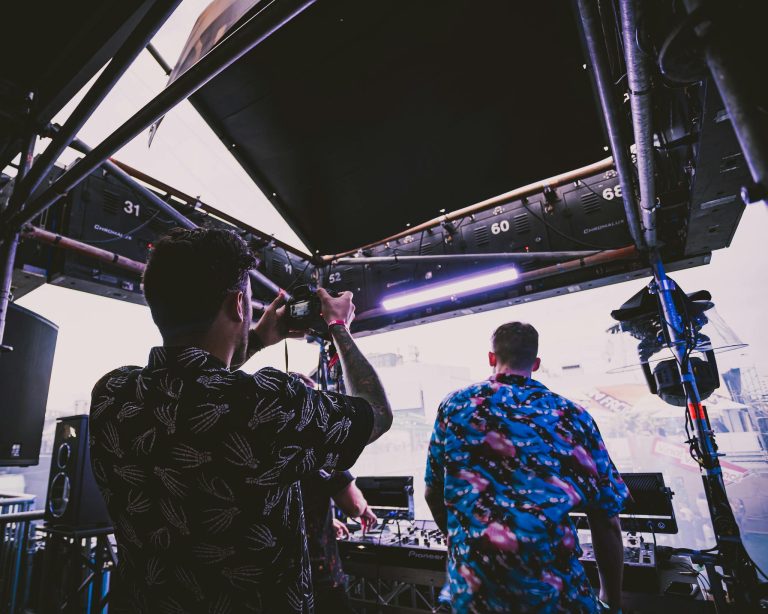 Engaging backstage view of a sound crew setting up for a live music event with a vibrant atmosphere.